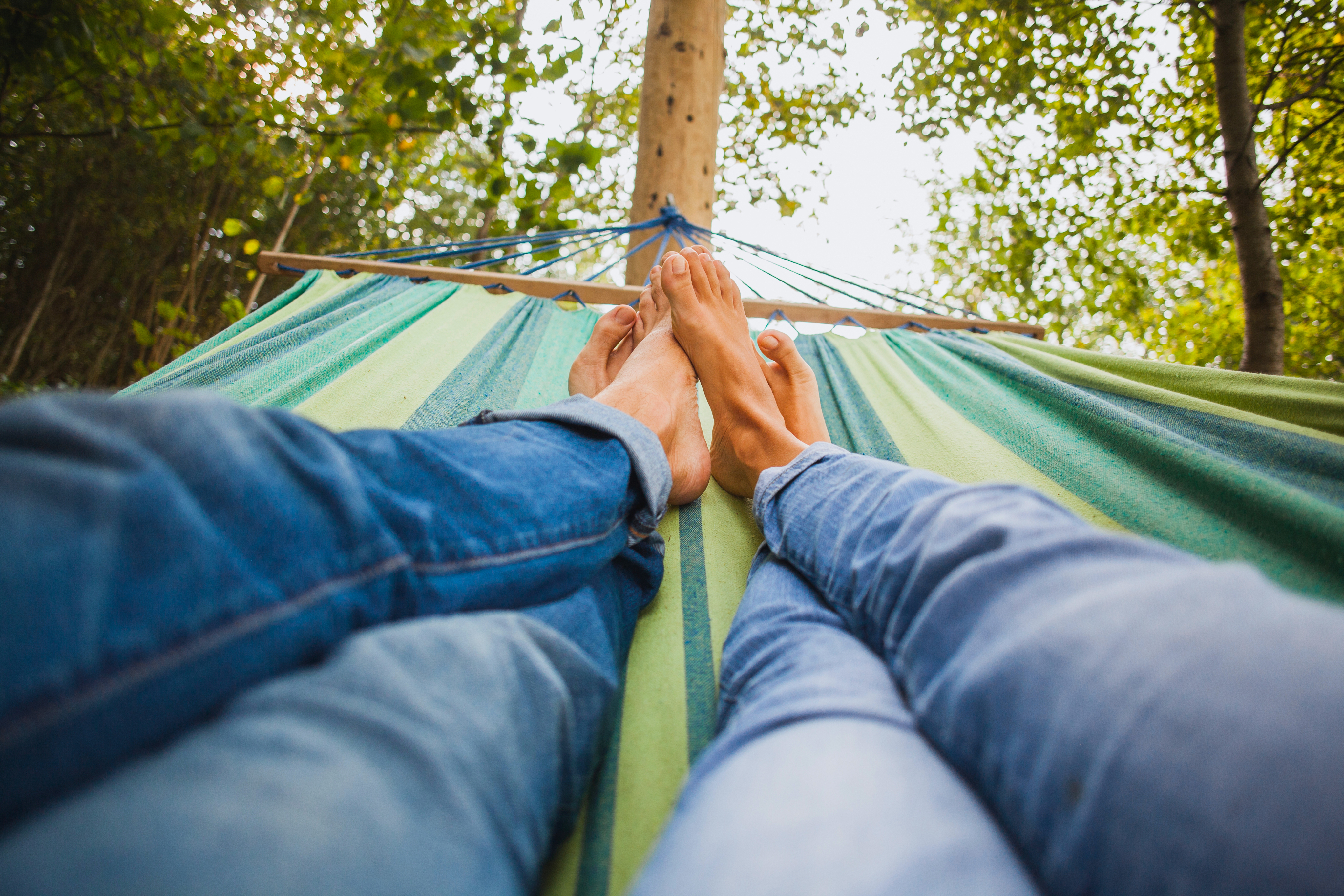 Pessoas a relaxar numa rede após transferirem o crédito habitação e aliviarem o orçamento